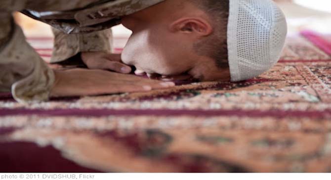 A person is prostrating during prayer.